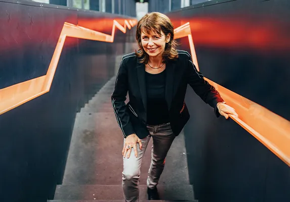 Carolin Wolf auf einer Treppe, Artikel in Kontext 4/2019 (PDF)